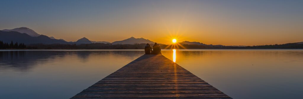Sonnenuntergang mit Gruppe sitzend am Steg am Hopfensee, Foto vom Fotograf und Webdesigner Bernhard Bartsch