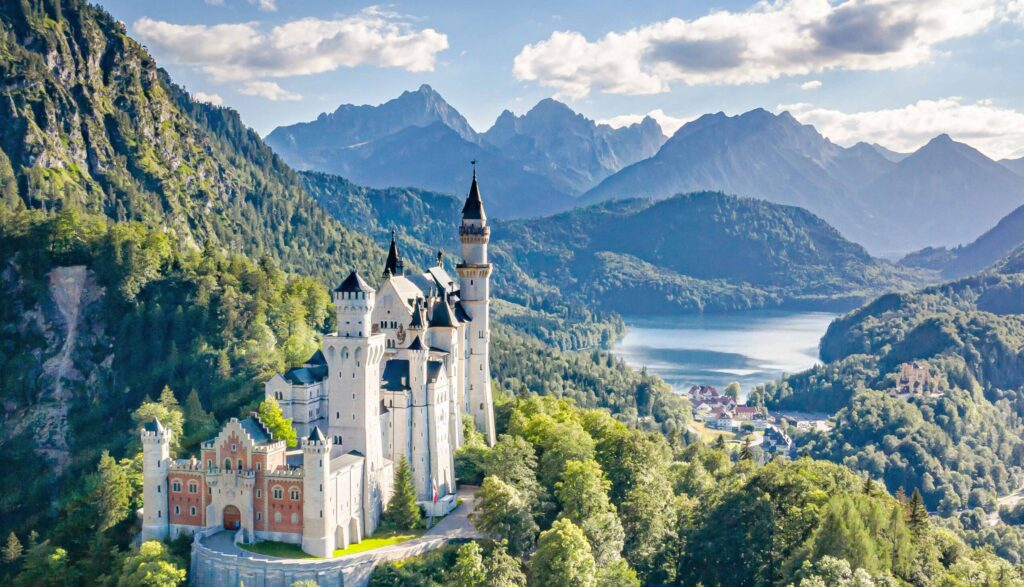 Das berühmte Schloss Neuschwanstein aus der Vogelperspektive, mit Bergen und dem Alpsee im Hintergrund, Foto vom Fotograf und Webdesigner Bernhard Bartsch